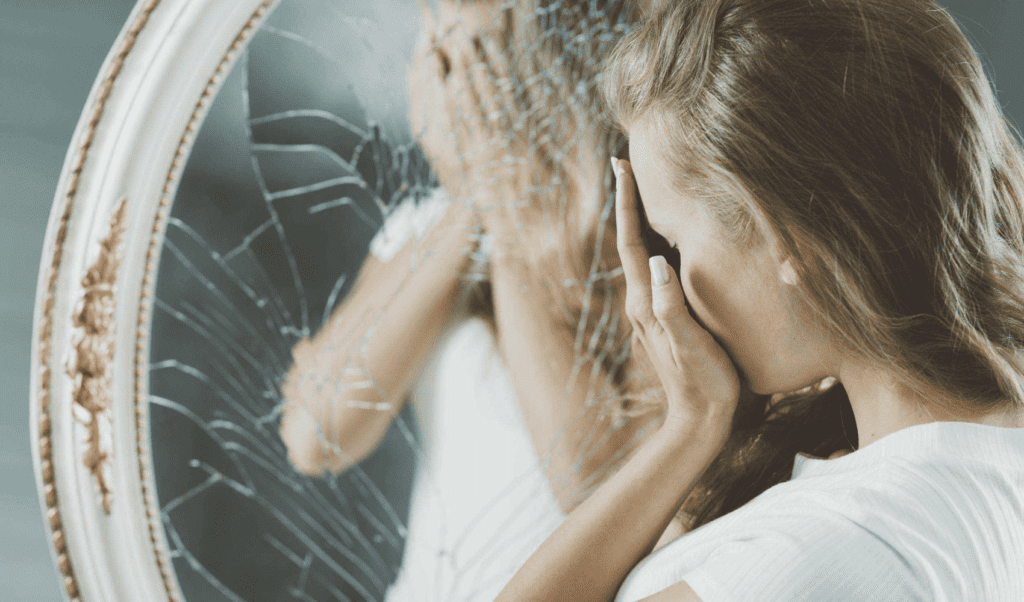 Женщина перед треснувшим зеркалом