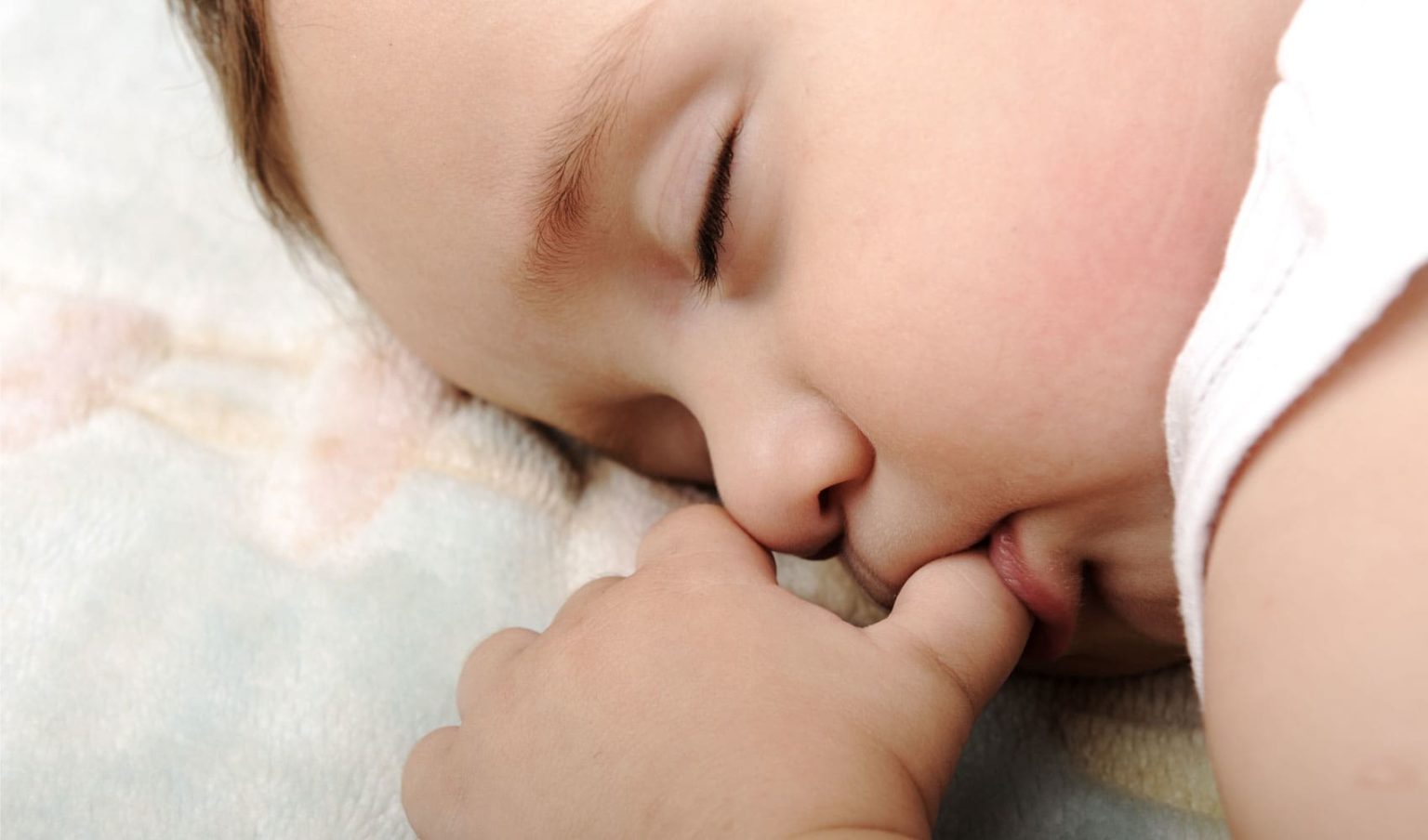 Спящий младенец. Сосательный рефлекс у младенца. Младенец с пальцем во рту. Сосание новорожденного.